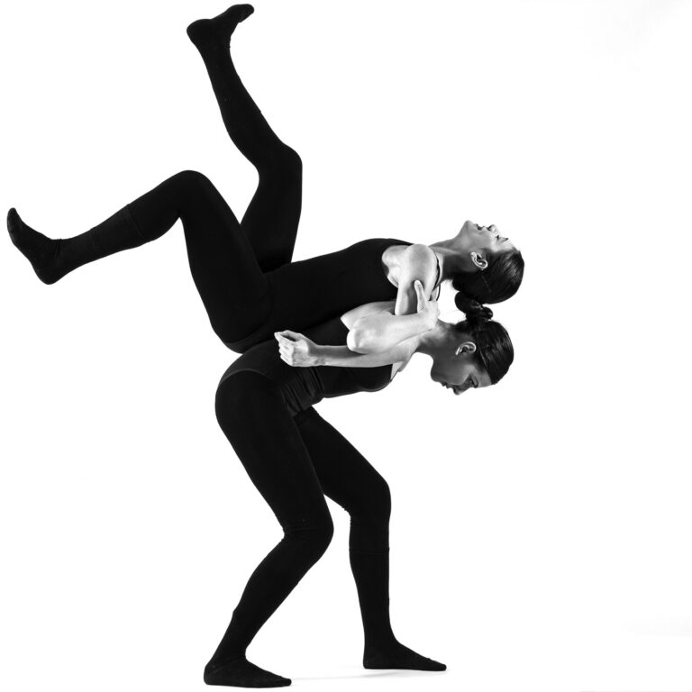 due ballerine eseguono una forma in equilibrio, schiena contro schiena